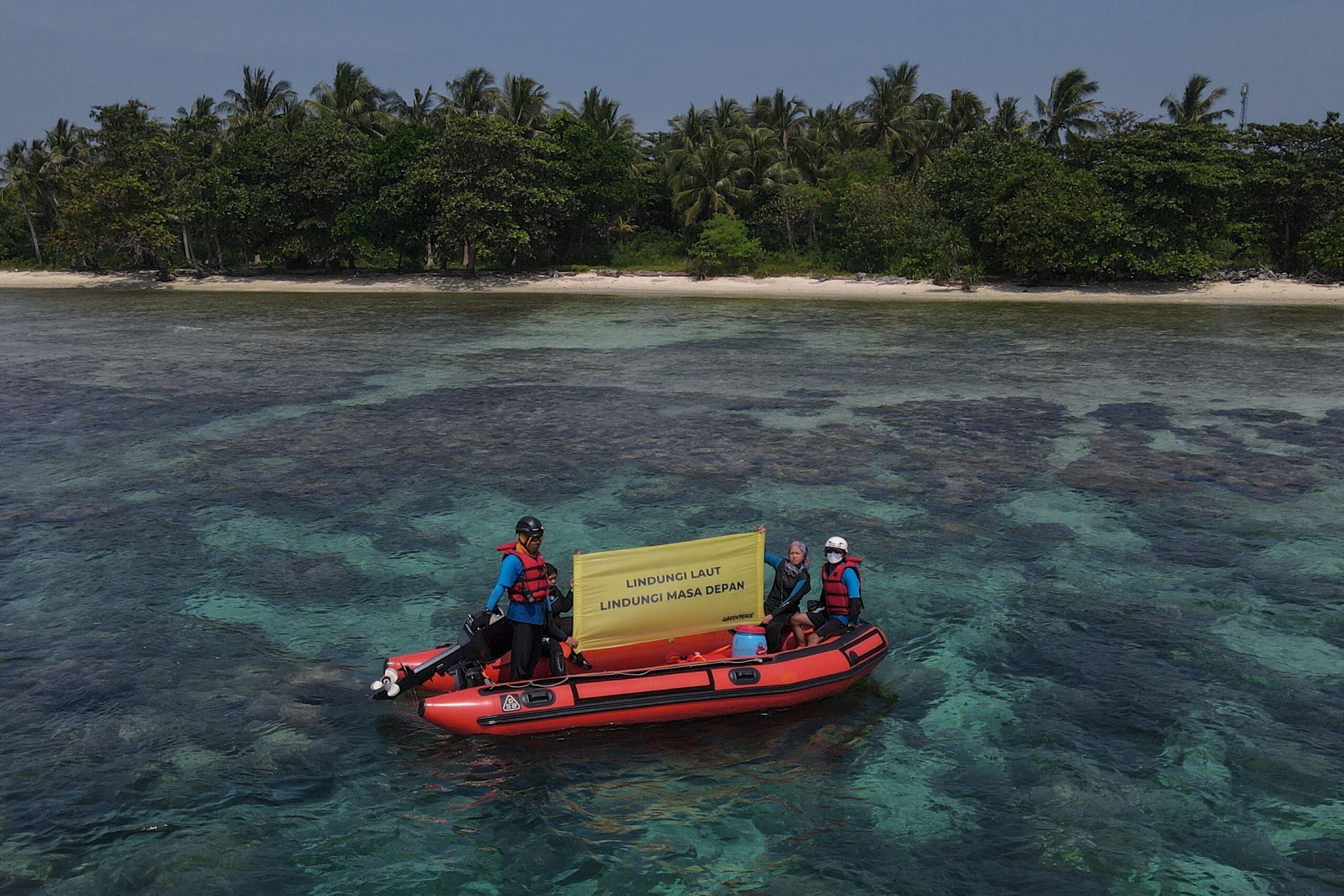 aktivis greenpeace membentangkan banner